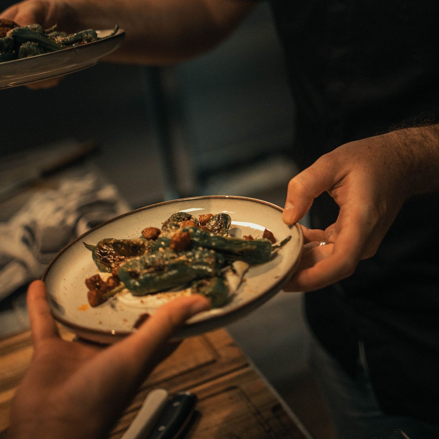 Pimientos de padrón on goat's cheese cream with dukkah, handed across the counter